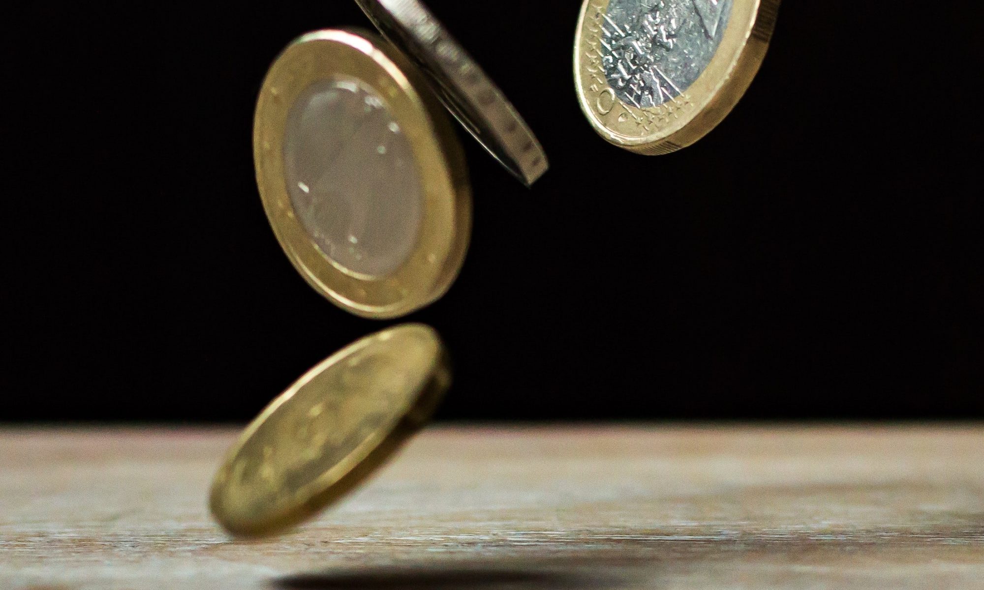 Münzen fallen auf einen Tisch